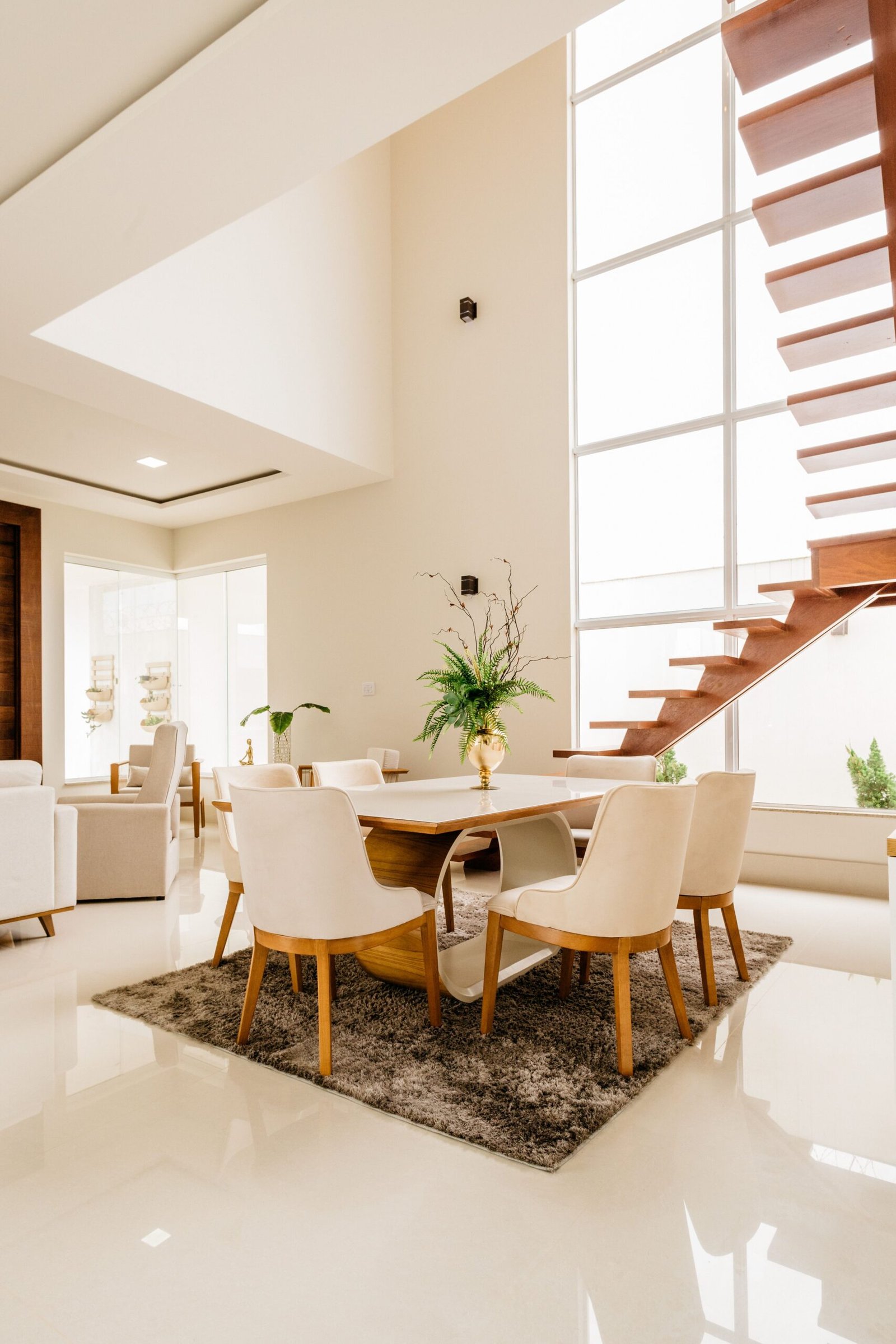 Stylish interior of spacious living room with minimalistic design with big windows and light furniture with wooden details
